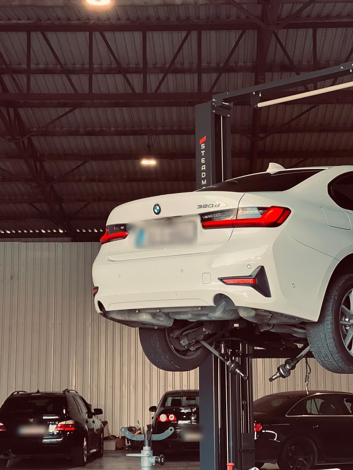 BMW 3 Series undergoing service on a lift at Car Avenue workshop in Ashbourne